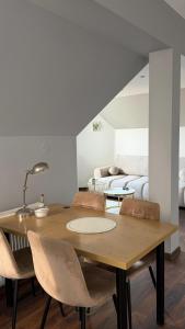 a dining room with a table and chairs and a couch at Apartament Widok in Nowy Targ