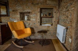 a living room with a chair and a table at O rincón de Agrón in Melide