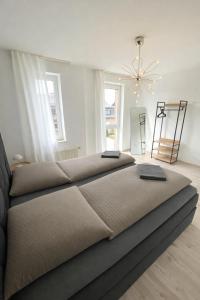 a large bedroom with two beds and a chandelier at Apartment mit Balkon - Nähe CHIO Aachen in Herzogenrath