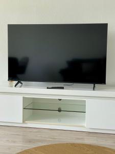 a flat screen tv sitting on top of a white entertainment center at Apartment mit Balkon - Nähe CHIO Aachen in Herzogenrath