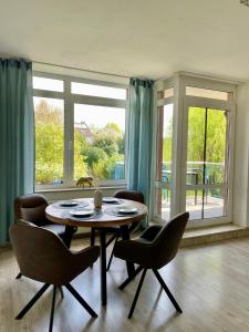 a dining room with a table and chairs and a large window at Apartment mit Balkon - Nähe CHIO Aachen in Herzogenrath