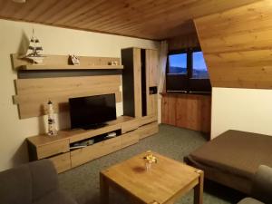 a living room with a television and a coffee table at Apartments Achterblick in Ueckeritz