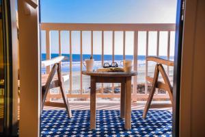 a table and two chairs on a balcony with the beach at Sunshine Daydream in Folly Beach