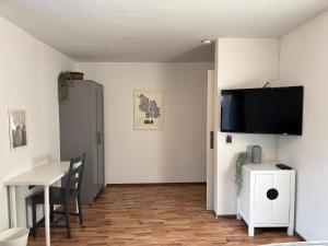 a dining room with a table and a tv on a wall at Wohnzeit-Köln in Cologne
