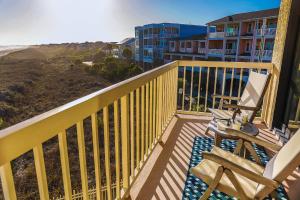 a balcony with a bench and a view of the beach at Sunshine Daydream in Folly Beach