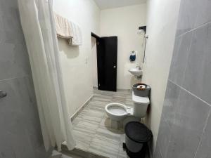 a bathroom with a toilet and a black door at Suite El Ángel #7 in Tuxtla Gutiérrez +10 photos