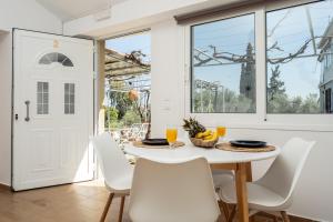 a white dining room with a white table and chairs at Destinys Village II in Zakynthos