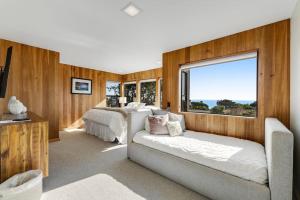 a bedroom with two beds and a couch and a window at Breakers Retreat in Sea Ranch
