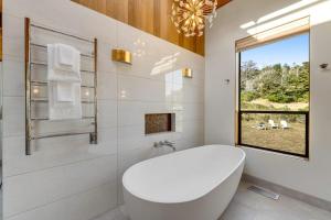 a white bathroom with a tub and a window at Breakers Retreat in Sea Ranch +39 photos