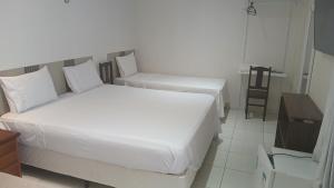 ein Schlafzimmer mit zwei Betten und einem Tisch in der Unterkunft Ruan Beach in Guajiru