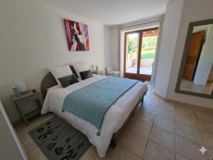 a bedroom with a bed and a large window at Les Mémis in Brantome en Perigord