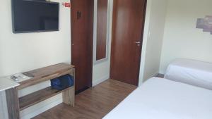 ein kleines Zimmer mit einem Bett und einem Fernseher in der Unterkunft Ruan Beach in Guajiru