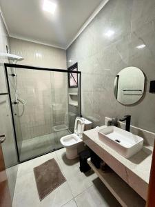 a bathroom with a toilet and a sink and a shower at Casa Centro de Socorro prox a Feira de malhas in Socorro +28 photos