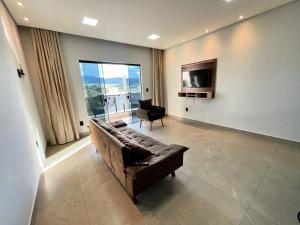 a living room with a couch and a television at Casa Centro de Socorro prox a Feira de malhas in Socorro