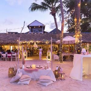 a table on the beach with people in a restaurant at 1 min walk beach,bars,grocery in Punta Cana