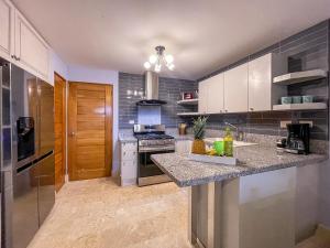 a kitchen with white cabinets and a counter top at 1 min walk beach,bars,grocery in Punta Cana