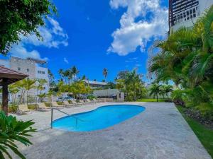 a swimming pool in a resort with chairs and palm trees at 1 min walk beach,bars,grocery in Punta Cana