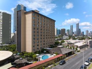 a tall building with a pool in front of a city at Pagoda Hotel in Honolulu