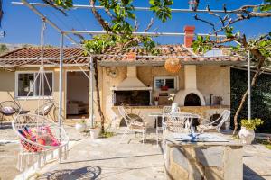 a patio with chairs and tables in front of a house at Destinys Village II in Zakynthos