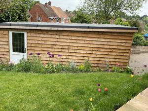 ein Holzschuppen in einem Garten mit Rasen in der Unterkunft Clauds Close in Hughenden