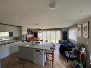 eine Küche und ein Wohnzimmer mit Sofa und Tisch in der Unterkunft Clauds Close in Hughenden