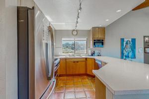 a kitchen with a stainless steel refrigerator and a window at Windrow Retreat in Sea Ranch