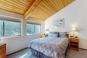 a bedroom with a large bed and two windows at Prentiss Retreat in Sea Ranch +19 photos