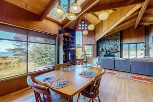 a dining room with a table and some windows at Meyer Getaway in Sea Ranch