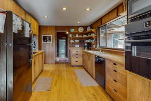 a kitchen with wooden floors and a stainless steel refrigerator at Meyer Getaway in Sea Ranch