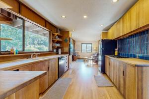 a large kitchen with wooden cabinets and a large window at Meyer Getaway in Sea Ranch +21 photos