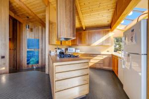 a kitchen with wooden cabinets and a white refrigerator at Samson Getaway in Sea Ranch