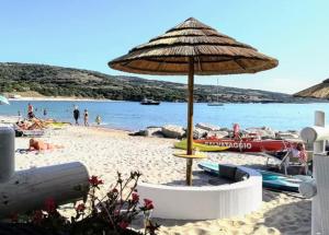 a beach with an umbrella and people on the beach at Il Centro in Tergu
