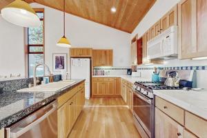 a kitchen with wooden cabinets and white appliances at Del Mar Meadow in Sea Ranch