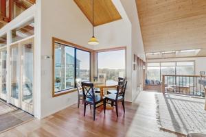 a dining room with a table and chairs and windows at Del Mar Meadow in Sea Ranch +21 photos