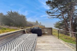 a bench sitting on a wooden boardwalk with a tent at Stoney House in Sea Ranch