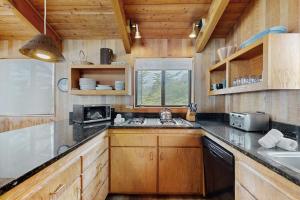 a kitchen with wooden cabinets and a sink at Stoney House in Sea Ranch