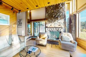 a living room with two chairs and a stone wall at Vista Grande in Sea Ranch