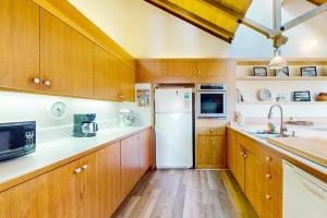 a kitchen with wooden cabinets and a white refrigerator at Vista Grande in Sea Ranch
