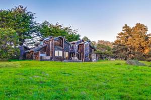 a wooden house in a field of green grass at Vista Grande in Sea Ranch