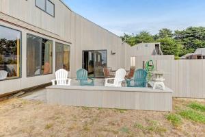 a group of white chairs sitting on a porch at Norman House in Sea Ranch