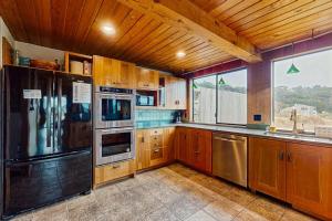 a kitchen with wooden cabinets and stainless steel appliances at Norman House in Sea Ranch