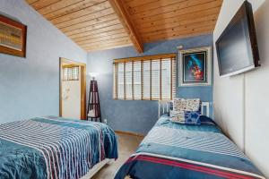 a bedroom with two beds and a flat screen tv at Ocean Star in Sea Ranch +16 photos