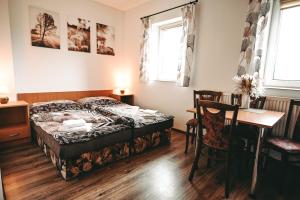 a bedroom with a bed and a table and chairs at Penzion U Kmotra in Borovany