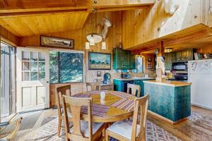 a kitchen and dining room with a table and a refrigerator at Thayer House in Sea Ranch