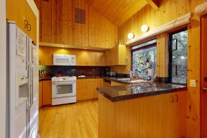 a kitchen with wooden cabinets and white appliances at Longwell House in Sea Ranch