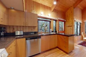 a kitchen with wooden cabinets and a stainless steel dishwasher at Longwell House in Sea Ranch