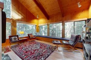 a living room with a couch and chairs and windows at Longwell House in Sea Ranch +16 photos