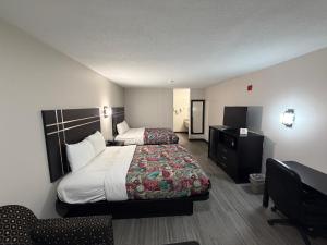 a hotel room with two beds and a desk at Sunset Inn in Brady +4 photos