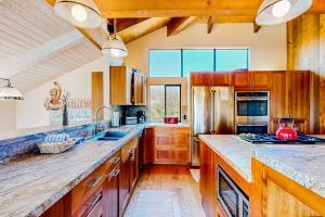 a kitchen with wooden cabinets and a large counter top at Cadwalader House in Sea Ranch