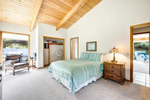 a bedroom with a bed and a table with a lamp at Casa Contenta in Gualala